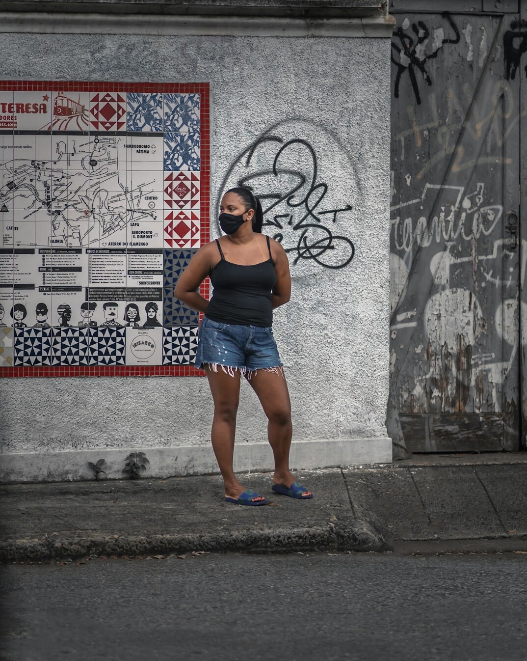 Young Chilean woman with a backpack waiting at a city bus stop