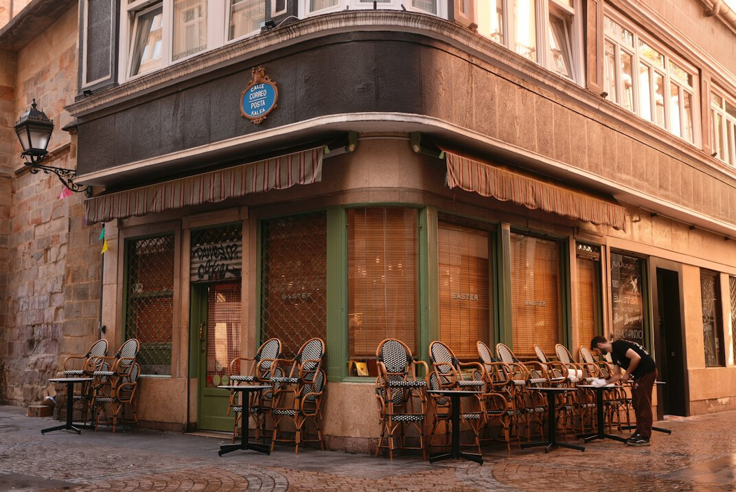 Corner cafe storefront with colorful walls and outdoor tables in Valparaiso